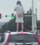 Angry woman climbs onto car roof on Chinese highway after 'arguing with husband'