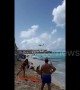 Beachgoers watch as planes fly low over Caribbean beach