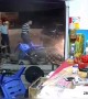 Car crashes into shop in southern China narrowly avoiding two men