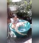 Little girl enjoys bath with pet lizard at Thai home