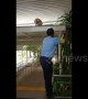 Kind security guard helps cat down from the roof by letting it climb on his shoulder