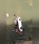 Residents save people trapped in car after it flips over into river in China