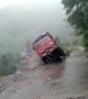 Pedestrians watch on as truck topples off cliff during landslide in northern India
