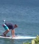 Man Struggles with Lakeside Paddleboard
