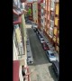 Man in Italy pours a drink for his neighbor two floors below