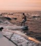 Pod of dolphins join wakeboarder under majestic sunset in epic slow motion