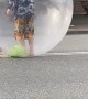 Performer Sings in Bubble While Rolling Down the Road