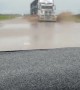 Truck Driving on Flooded Roads Covers Car