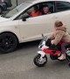 Kid on Toy Motorbike Challenges Driver to a Race