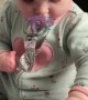 Determined baby overcomes disability to play with toy