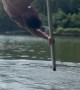 Man Dances On Flying Pole Over Peaceful Lake