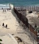 Migrants and Stray Dog Run Across Open US-Mexico Border Fence in Tijuana