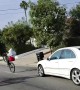 Car Races Through Large Pack Of Bicycles