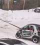 People Help Push A Mini Car Out Of The Snow