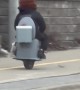 Man Riding a One-Wheeled Toilet Scooter