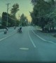 Elderly Bicyclist Pulling Cart Pushed by Passing Motorcyclist